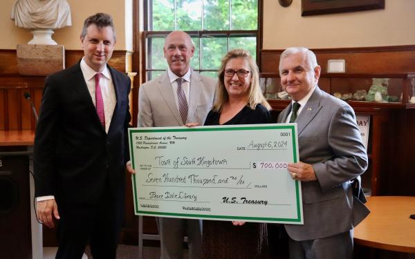 Rep Magaziner and others holding a large check