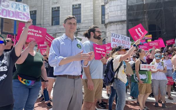 Representative Magaziner stands at rally