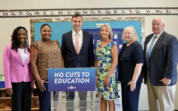 Representative Seth Magaziner (RI-02) standing with educators and parents