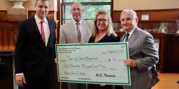 Rep Magaziner and others holding a large check
