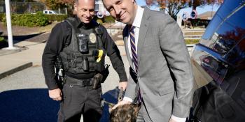 Rep. Magaziner poses with Cranston Police Department K-9 and officer at event to recognize the arrival of a new fleet of K-9 vehicles. 