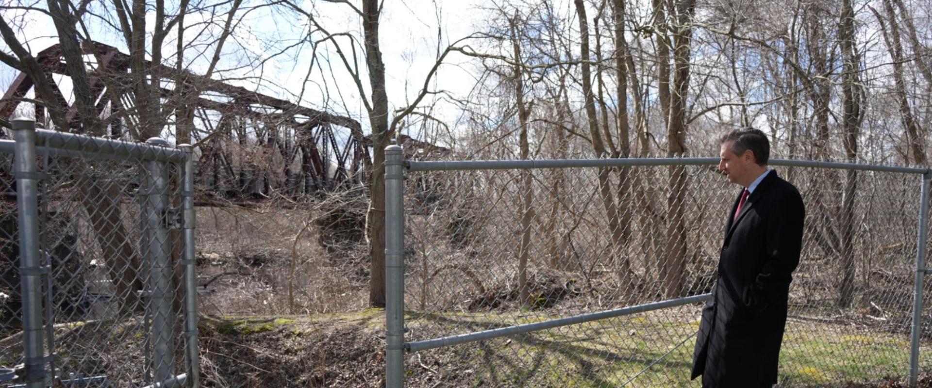 Magaziner standing near fence
